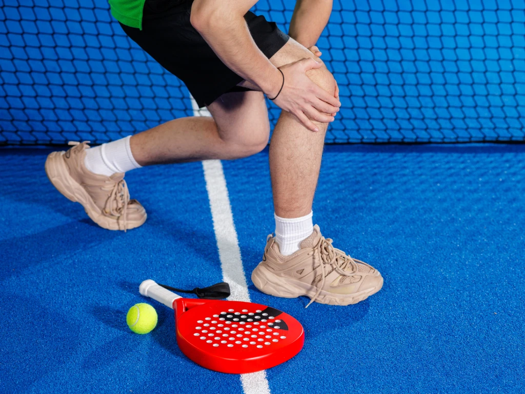 Athlete holding an injured knee during a sports activity