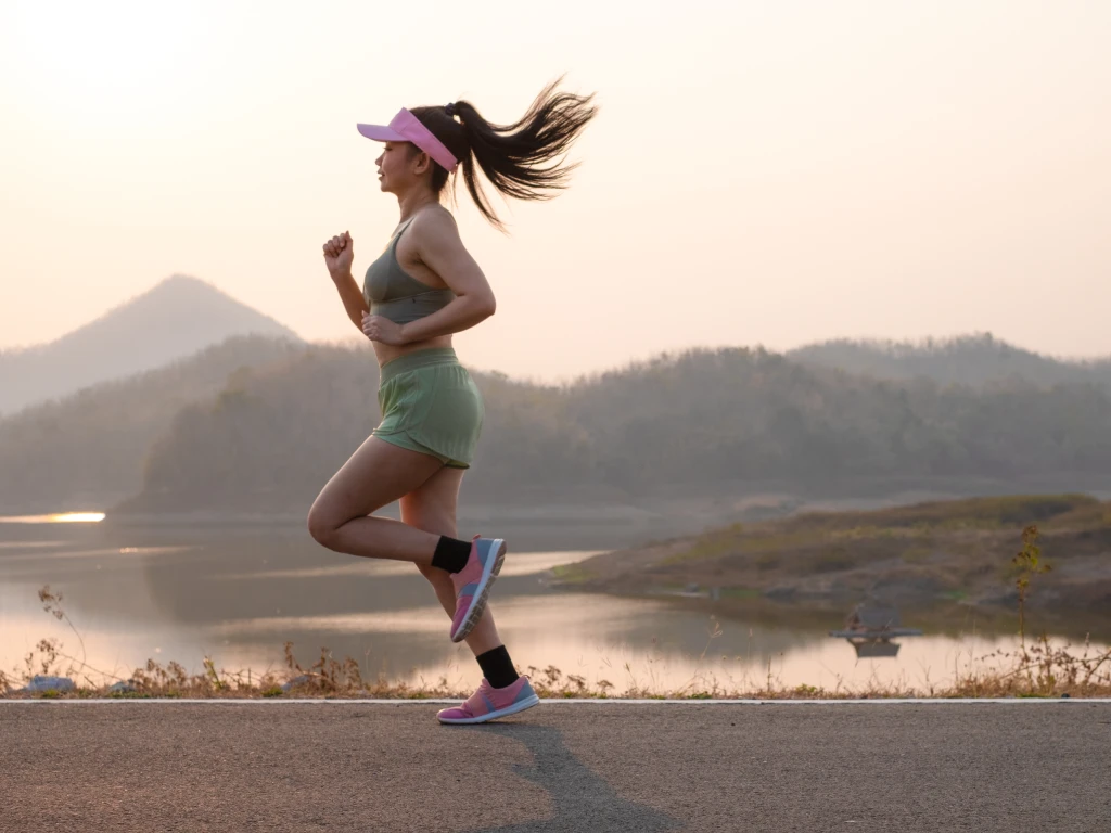 Woman experiencing knee pain while exercising outdoors
